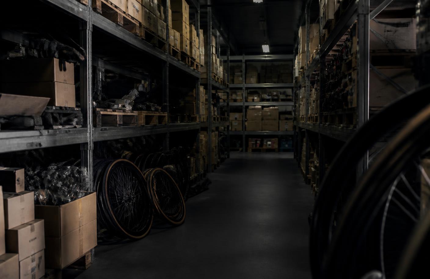 Mixed bicycle parts inventory on warehouse shelving